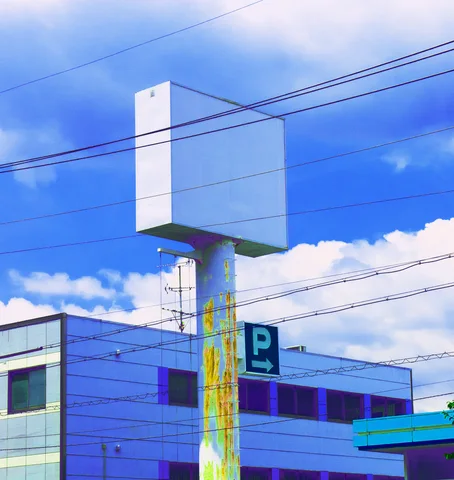 A blank white sign rises on a rust-streaked pole before overhead wires and blue sky.