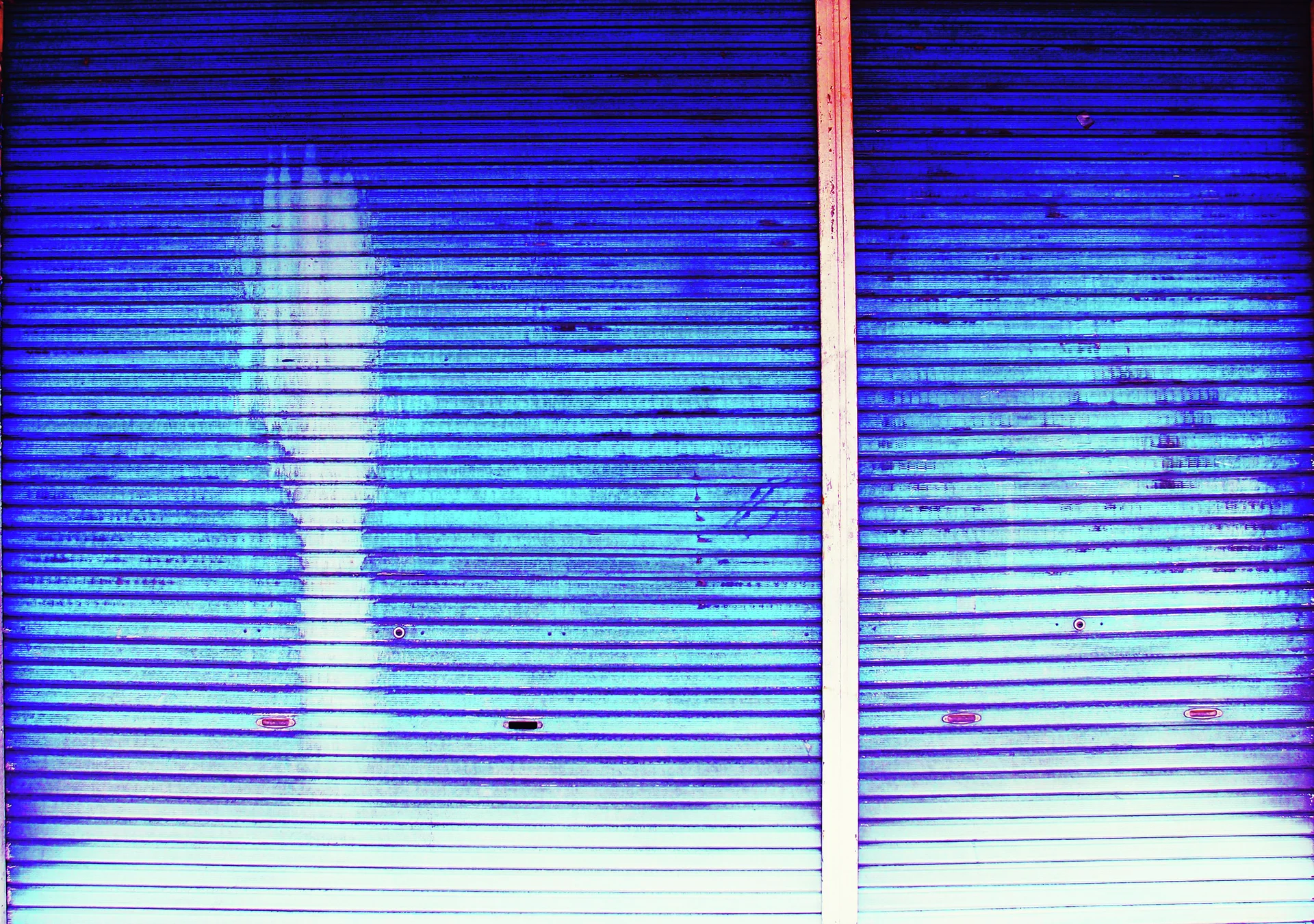 Two closed blue metal shutters reflect pale light across their closely spaced horizontal ridges.