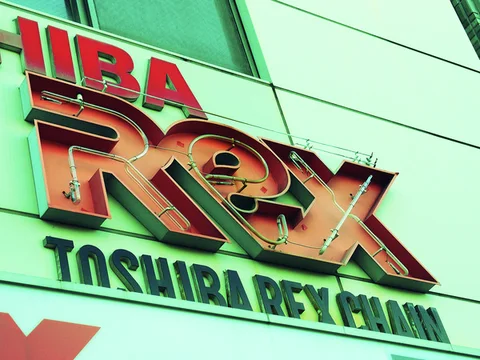 Large raised red and gold Rex lettering sits above dark lettering on a pale green facade.