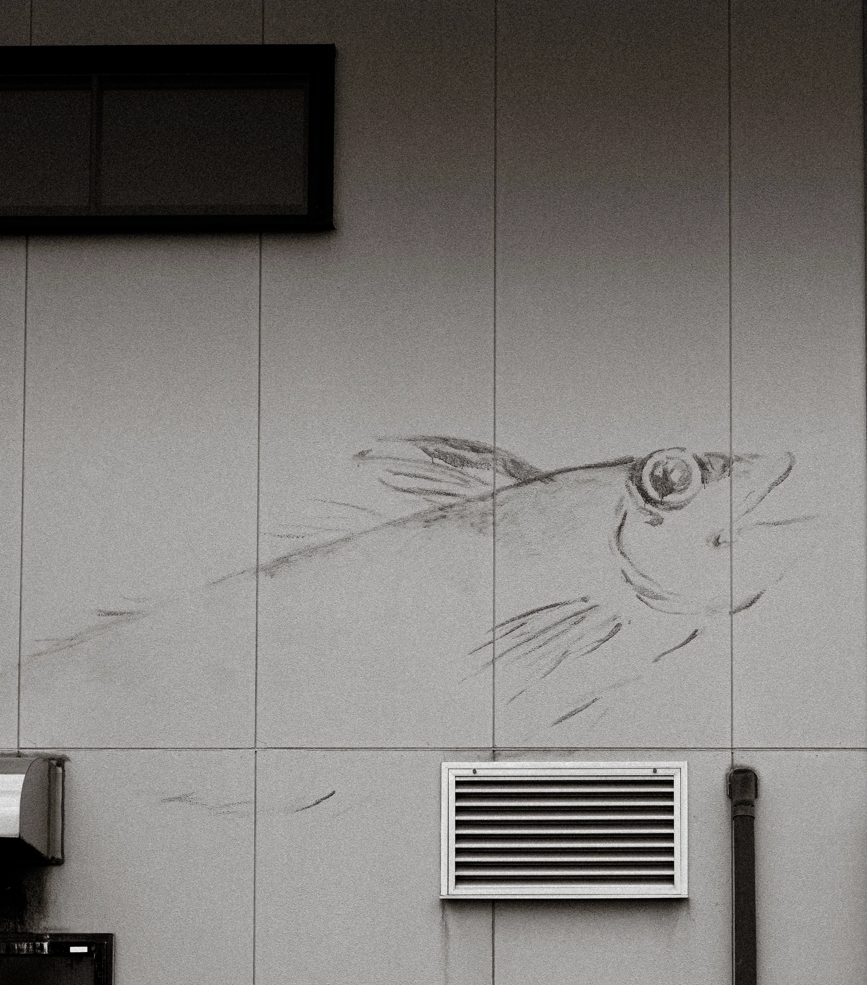 A faint bird-head drawing spreads across a pale paneled wall above a rectangular vent.