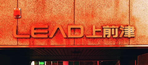 Red raised lettering and pale Japanese characters stretch across an orange textured facade above a dark overhang.