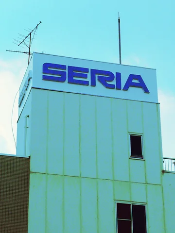 Blue SERIA lettering tops a narrow pale tower with antennas and small dark windows.