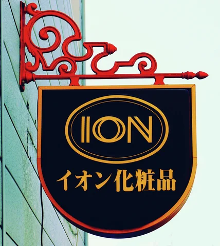 A dark shield-shaped ION sign hangs from an ornate red metal bracket.