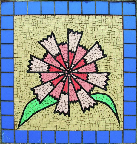 A pink jagged-petaled flower with green leaves forms a mosaic bordered by blue square tiles.