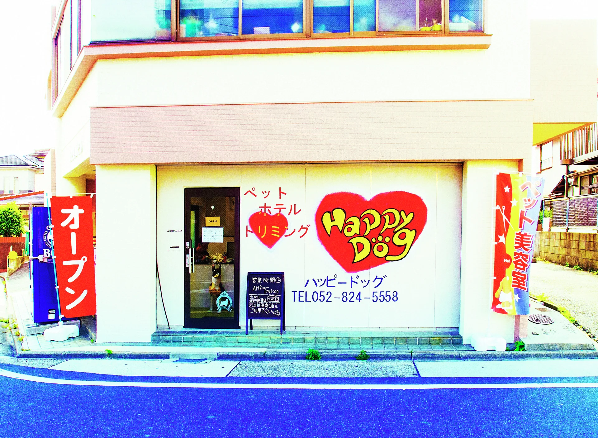 A red heart-shaped Happy Dog logo decorates a white corner storefront flanked by bright red banners.
