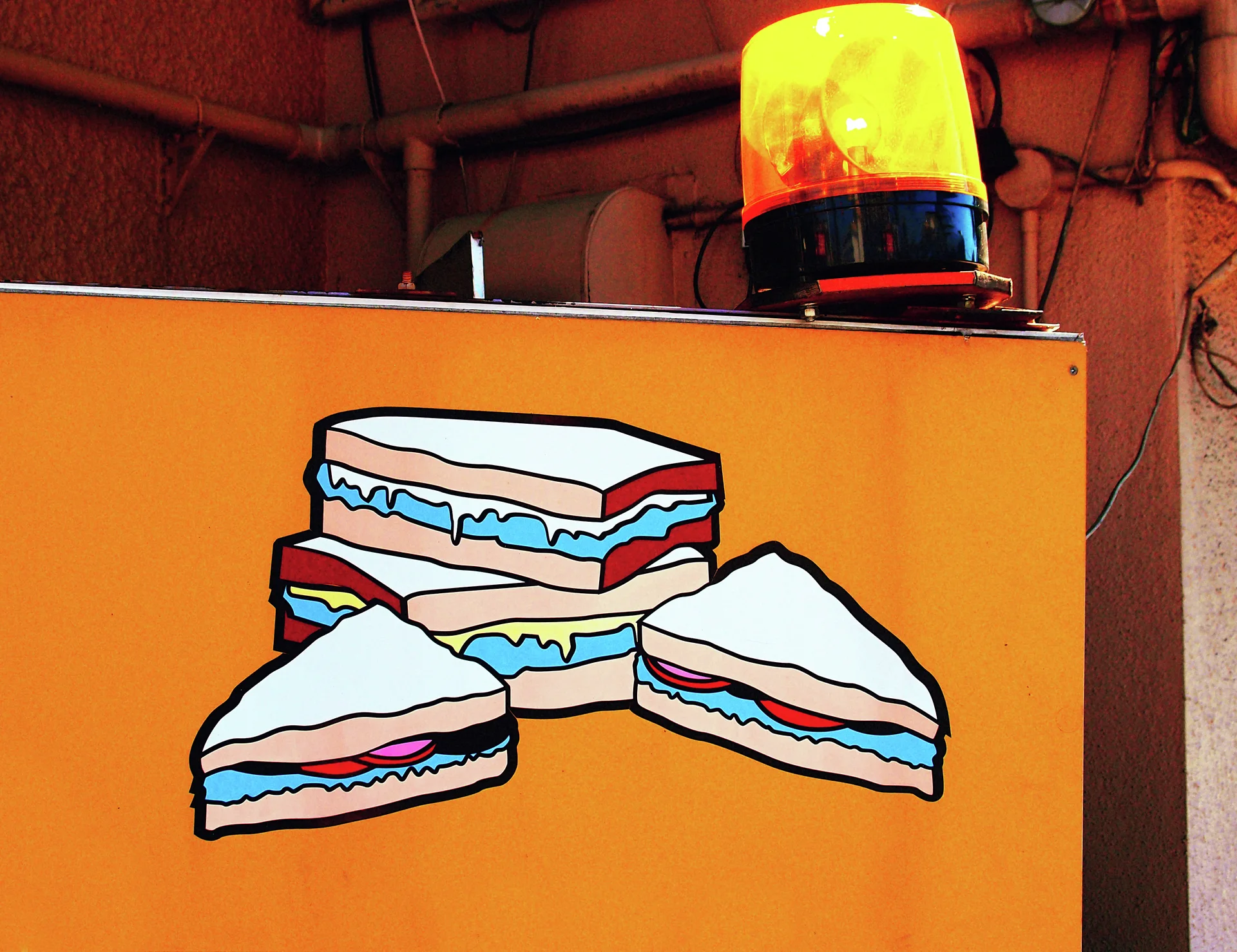 Colorful sandwich illustrations decorate an orange panel topped by a glowing yellow beacon.