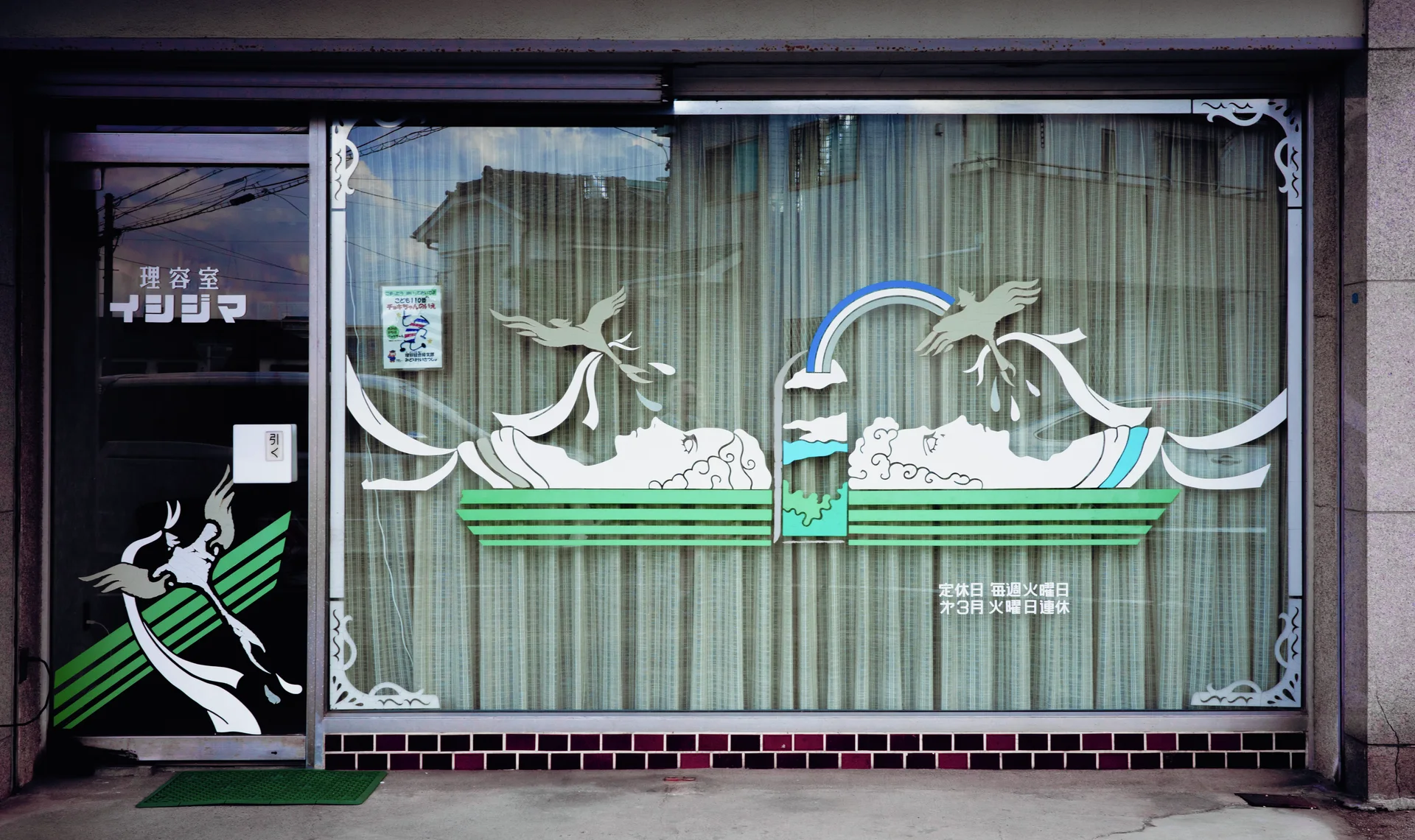 White bird and rainbow motifs stretch across a large curtained storefront window above green stripes.