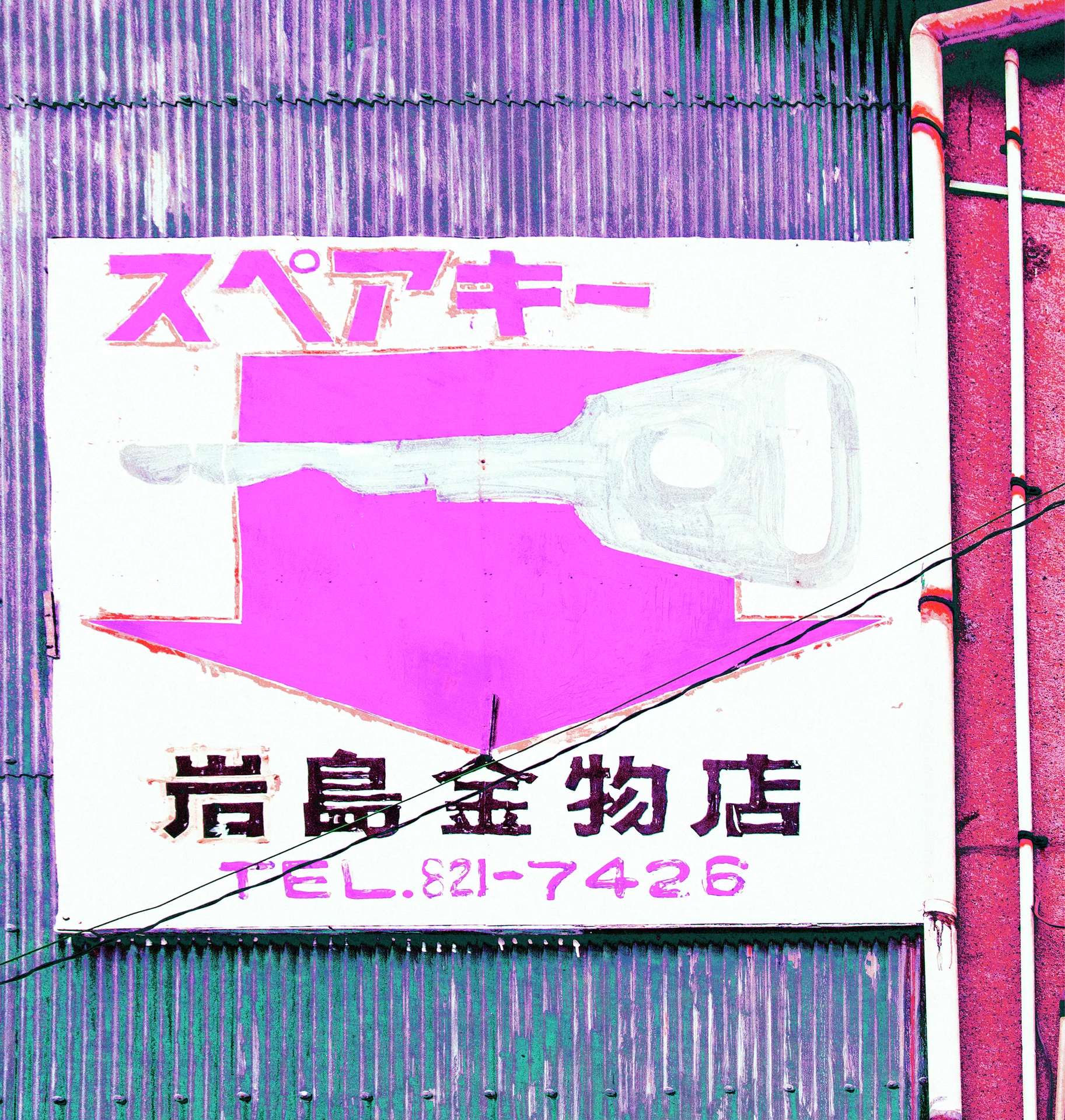A large key illustration and pink arrow fill a weathered shop sign against corrugated siding.