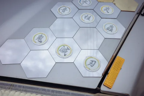 Circular Japanese labels sit within pale hexagonal tiles behind glass beside a small yellow reflector.