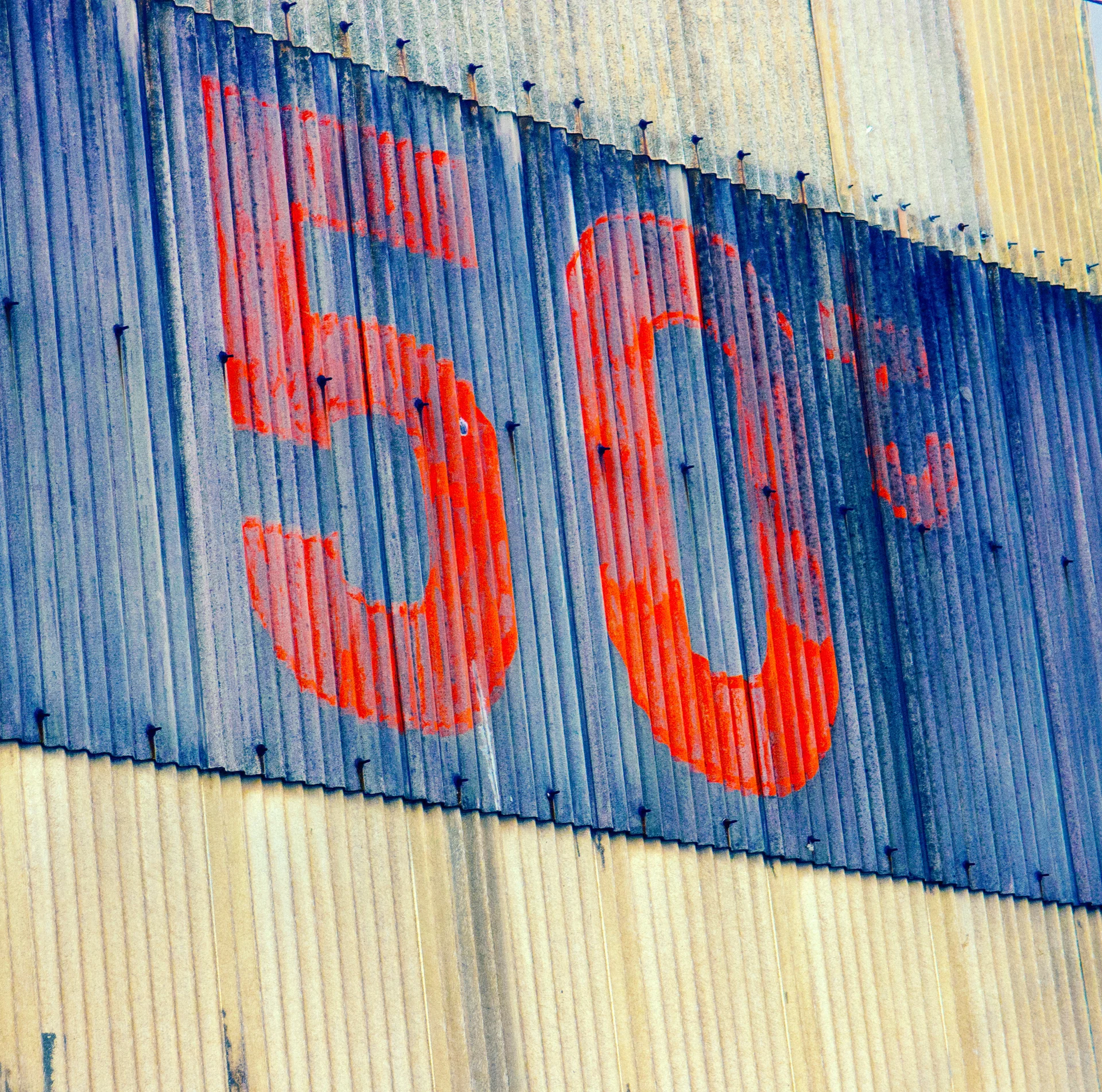 Faded red number 50 spans a dark blue stripe across pale corrugated metal siding.