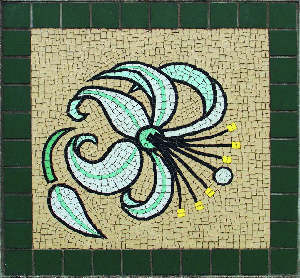 A pale curved-petaled flower with long dark stamens forms a mosaic bordered by dark green tiles.
