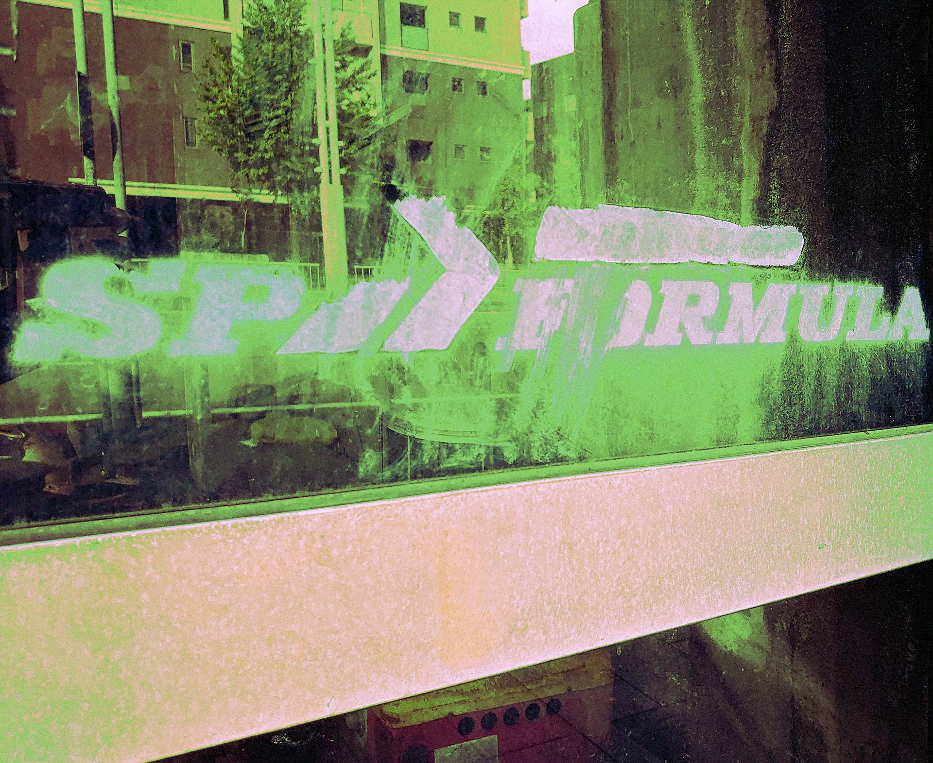 White arrow-shaped lettering spans reflective green-tinted glass above a broad pale panel.